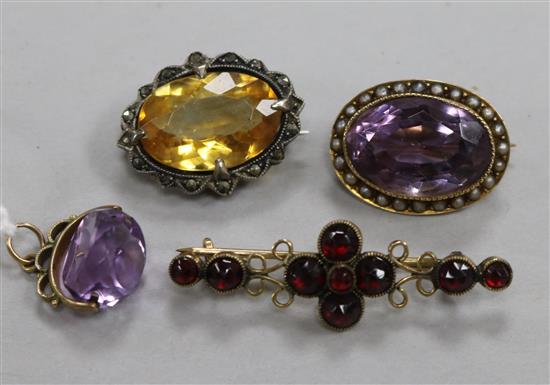 An early 20th century amethyst and split pearl brooch, an amethyst spinning fob pendant and two other brooches.